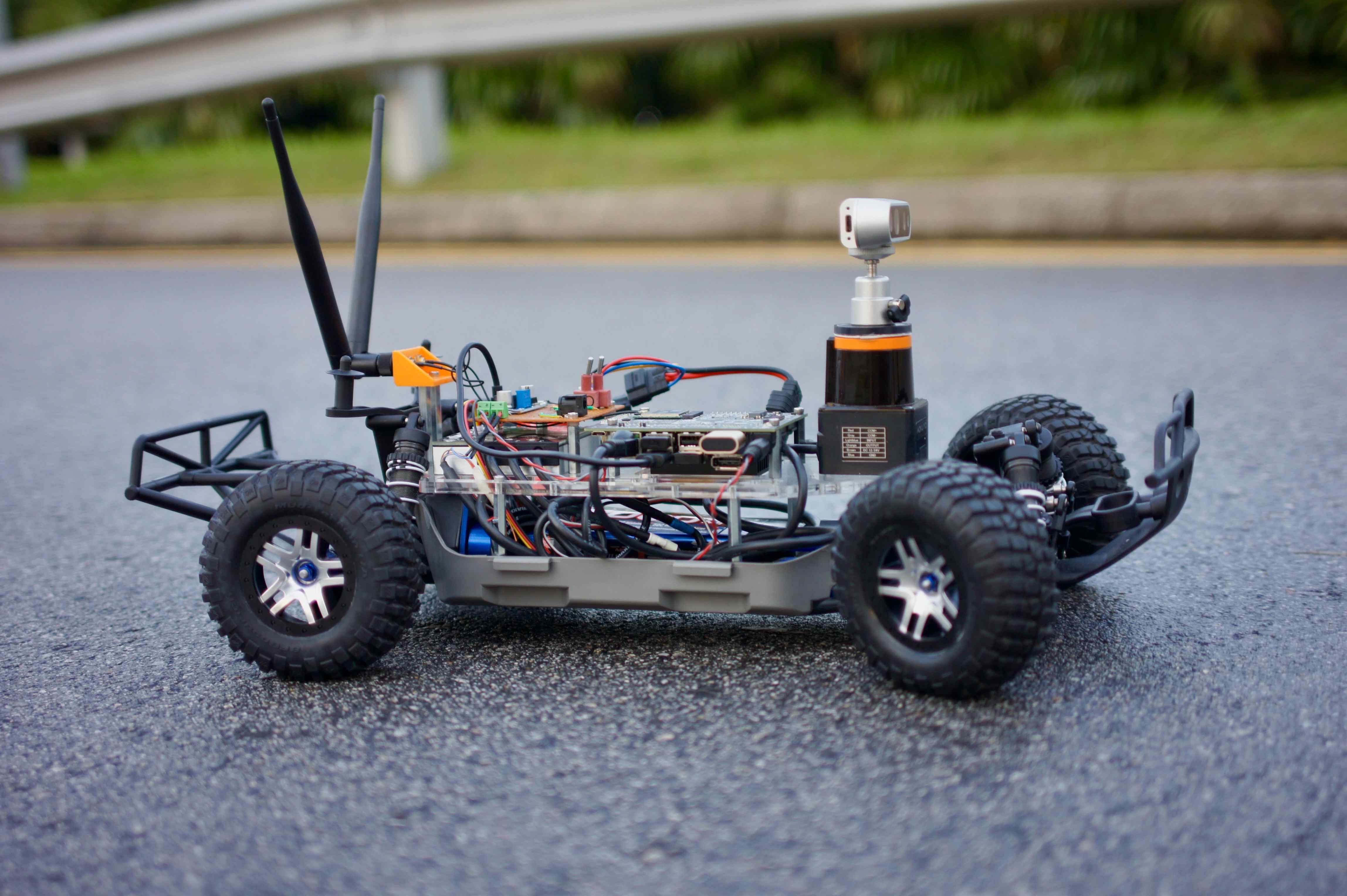 F1TENTH autonomous RC car with sensors and antennas on a road