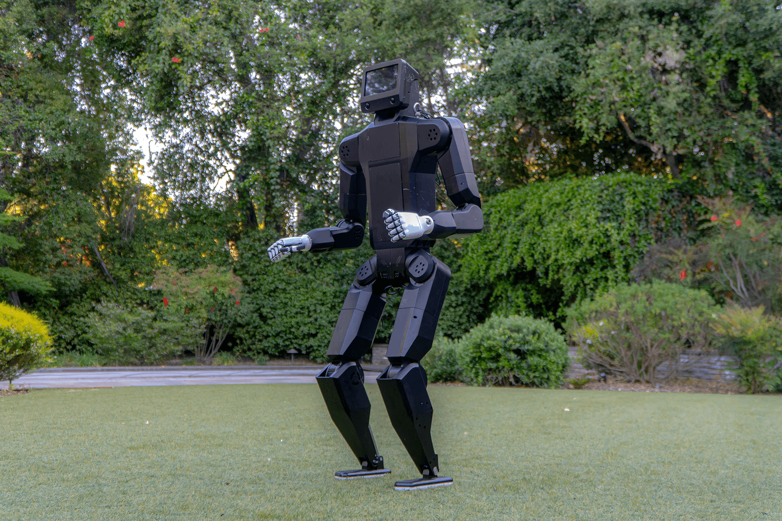 K-Bot humanoid robot walking outdoors on grass